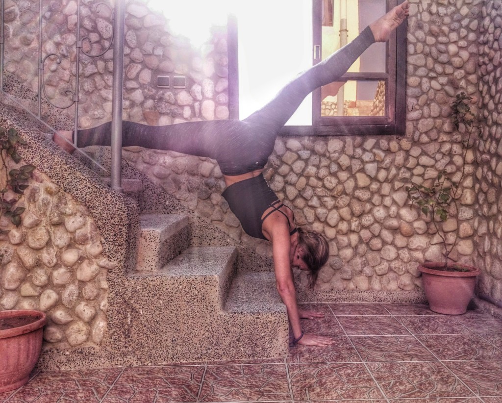 Image shows Jade practising handstands on the steps in Morocco to demonstrate how yoga makes you strong.