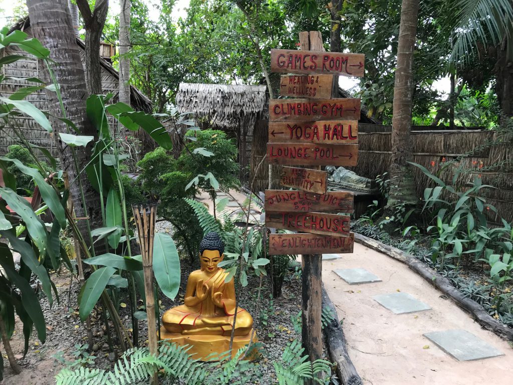 Signs pointing to yoga hall and other facilities at Hariharalaya Retreat Centre.